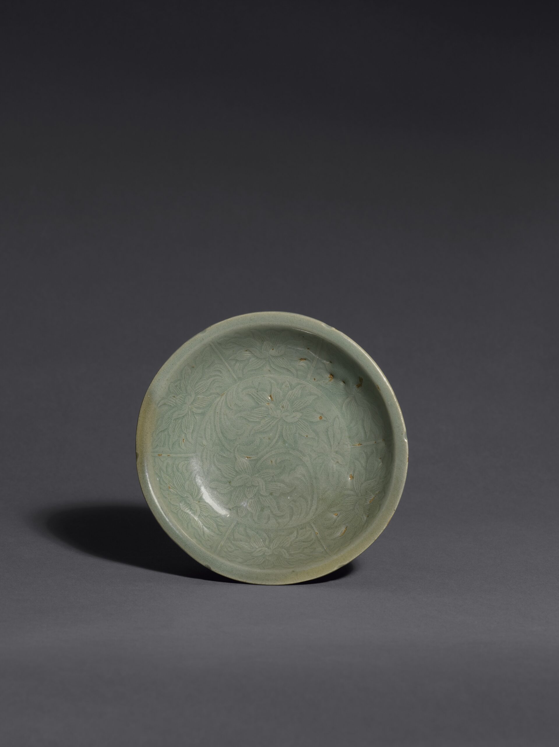 A CARVED KOREAN CELADON LOTUS-PATTERN FLOWER-SHAPED DISH Goryeo dynasty (918-1392), 12th century Diameter: 11.8 cm, 4⅝ inches 高麗 十二世紀 青瓷刻蓮花紋碟 直徑11.8釐米 A CARVED KOREAN CELADON LOTUS-PATTERN FLOWER-SHAPED DISH Goryeo dynasty (918-1392), 12th century Diameter: 11.8 cm, 4⅝ inches 高麗 十二世紀 青瓷刻蓮花紋碟 直徑11.8釐米