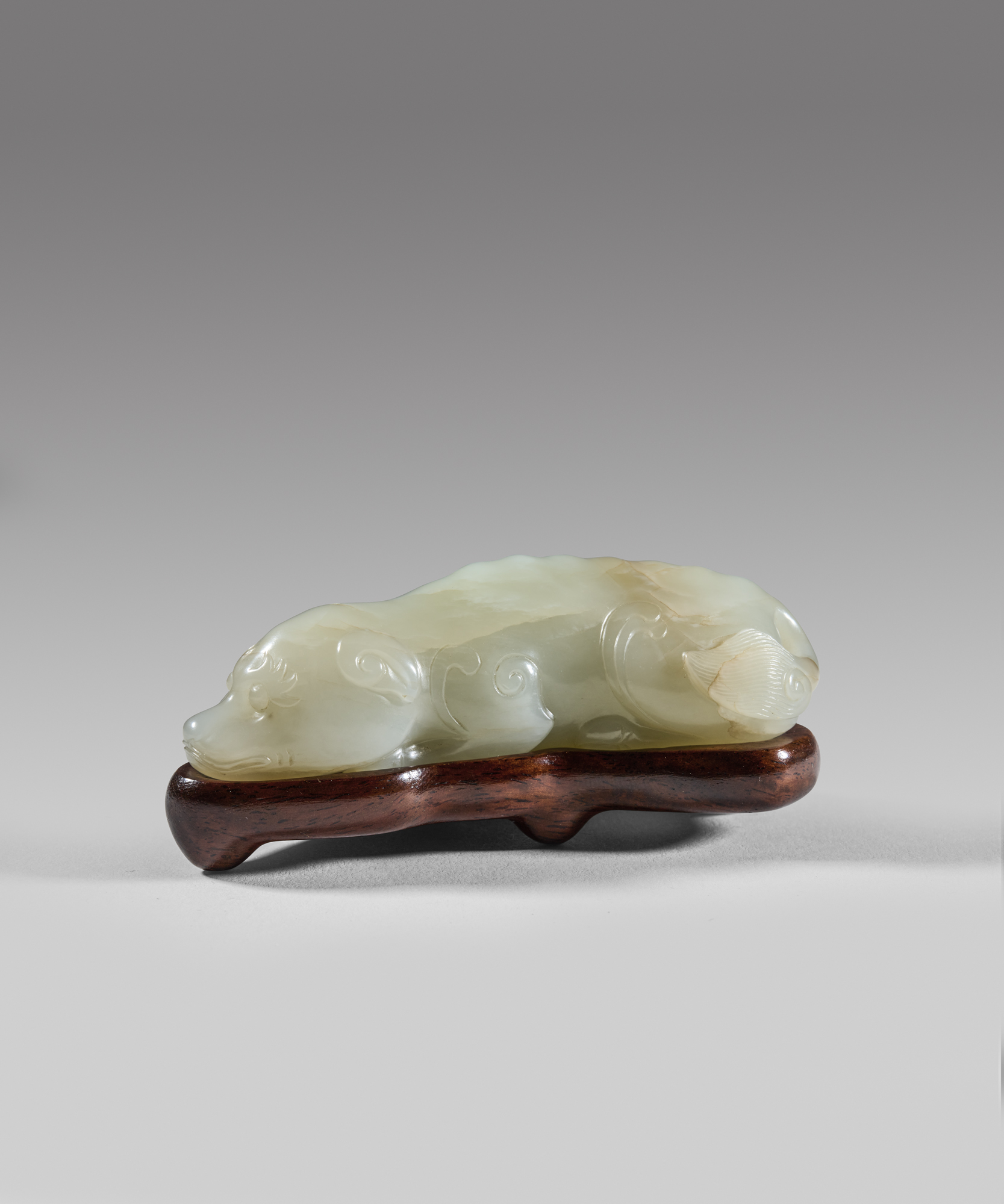 A pale celadon jade carving of a recumbent dog (Song dynasty, 960-1279)