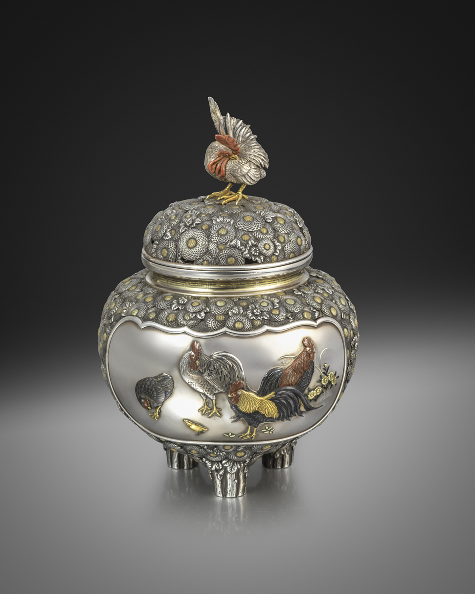 An inlaid silver koro and cover with two panels inlaid in silver, copper, gold, shakudo and shibuichi, the body carved with numerous overlapping chrysanthemums, Signed on a gilt plaque Setsuho Hidetomo, Meiji Period Circa 1890 An inlaid silver koro and cover with two panels inlaid in silver, copper, gold, shakudo and shibuichi, the body carved with numerous overlapping chrysanthemums, Signed on a gilt plaque Setsuho Hidetomo, Meiji Period Circa 1890