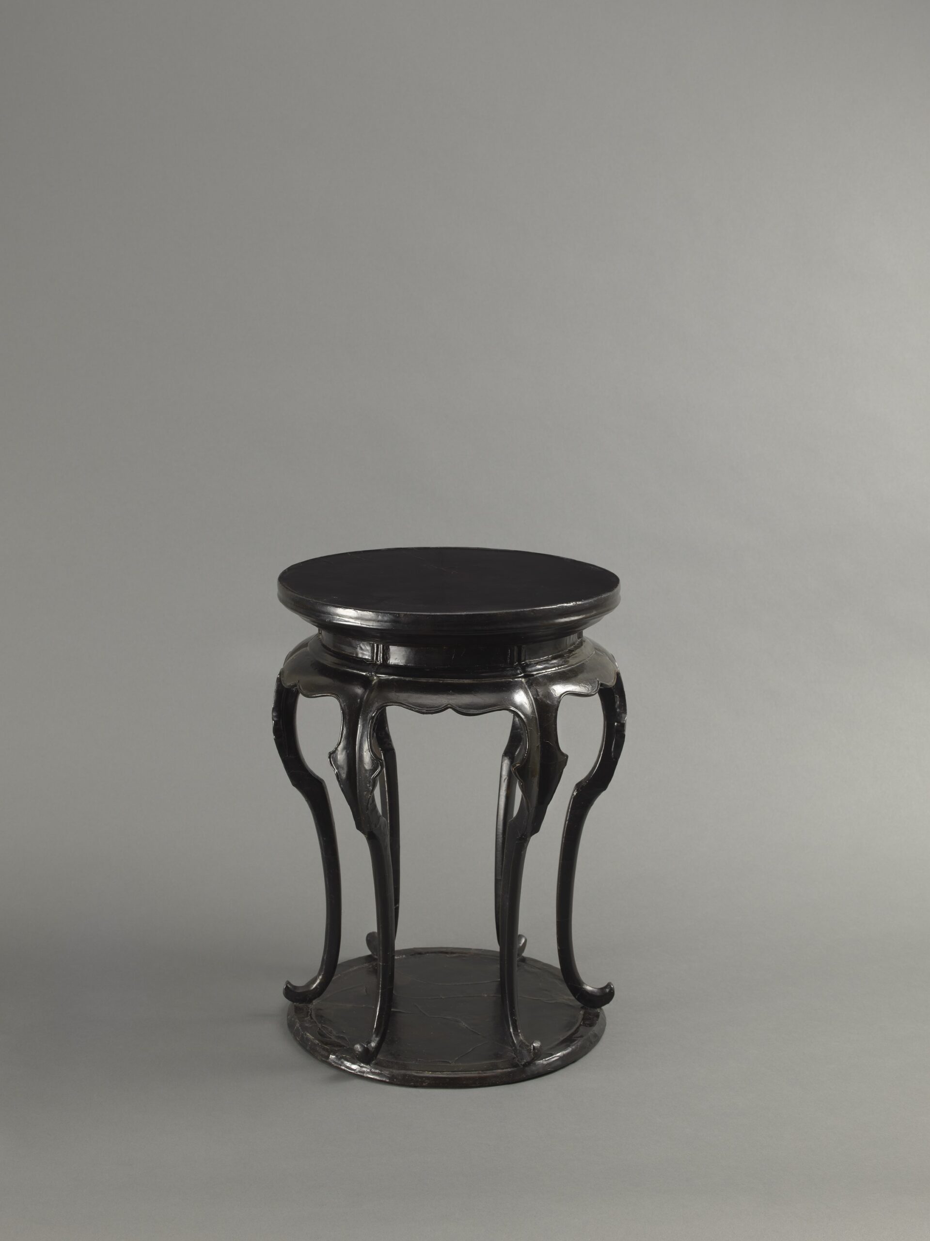 A BLACK LACQUERED WOOD SIX-LEGGED INCENSE STAND, XIANGJI Southern Song dynasty (1127-1279) or early Yuan dynasty (1279-1368) Height: 39 cm, 15 ⅜ inches 南宋至元早期 黑漆高束腰六足圓香几 高39釐米 A BLACK LACQUERED WOOD SIX-LEGGED INCENSE STAND, XIANGJI Southern Song dynasty (1127-1279) or early Yuan dynasty (1279-1368) Height: 39 cm, 15 ⅜ inches 南宋至元早期 黑漆高束腰六足圓香几 高39釐米