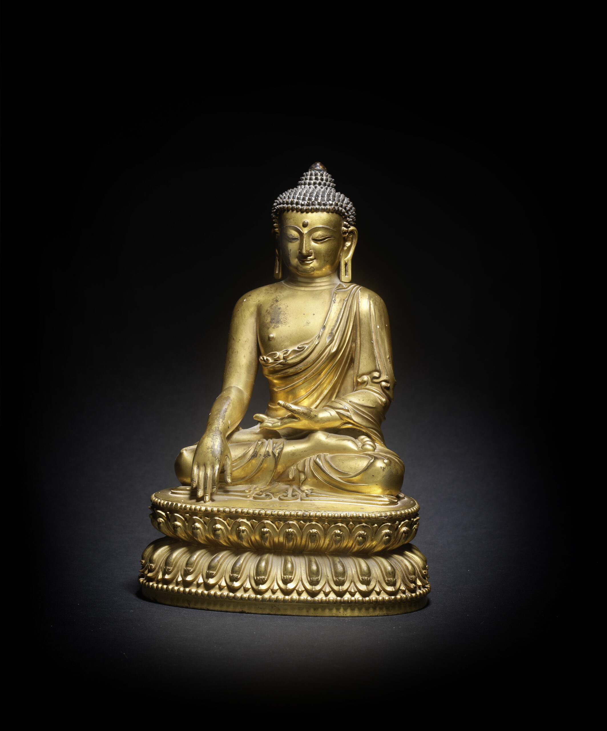 A MAGNIFICENT GILT-BRONZE FIGURE OF SHAKYAMUNI BUDDHA Yongle incised six-character mark and of the period A MAGNIFICENT GILT-BRONZE FIGURE OF SHAKYAMUNI BUDDHA Yongle incised six-character mark and of the period