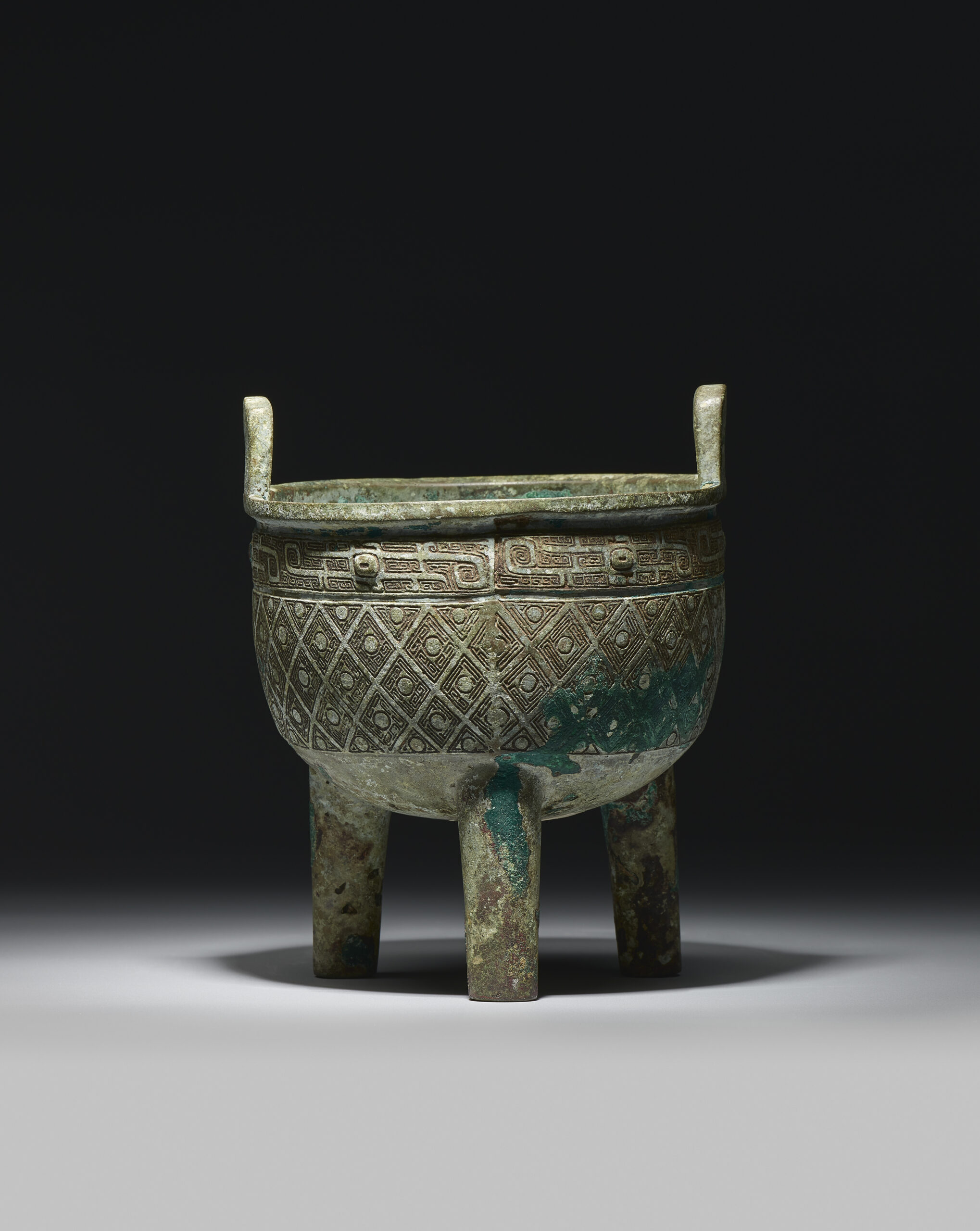 A RARE ARCHAIC BRONZE RITUAL TRIPOD VESSEL, DING Early Western Zhou Dynasty A RARE ARCHAIC BRONZE RITUAL TRIPOD VESSEL, DING Early Western Zhou Dynasty
