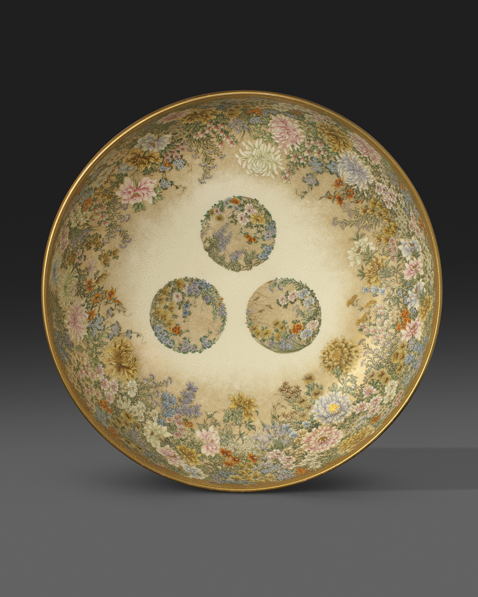 A large earthenware bowl, finely painted and gilt on both interior and exterior with numerous flowers. Signed and impressed Kinkozan zo, Meiji Period Circa 1900, 28.2cm A large earthenware bowl, finely painted and gilt on both interior and exterior with numerous flowers. Signed and impressed Kinkozan zo, Meiji Period Circa 1900, 28.2cm