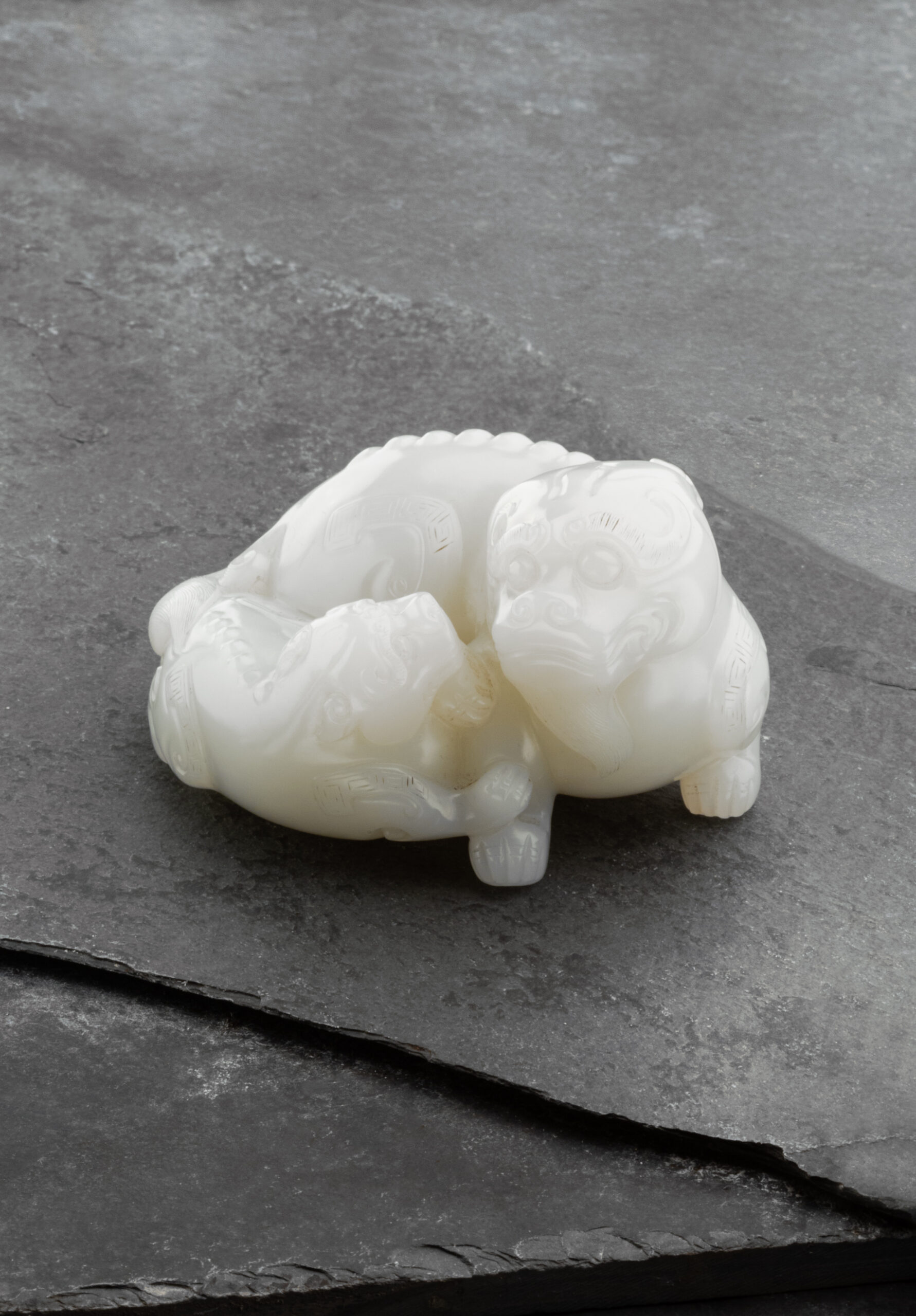 A FINE CARVED WHITE JADE MYTHICAL BEAST AND CUB | Qing Dynasty, Qianlong Period (1736-1795) | Length: 7.5 cm, 3 ̋ Inches A FINE CARVED WHITE JADE MYTHICAL BEAST AND CUB | Qing Dynasty, Qianlong Period (1736-1795) | Length: 7.5 cm, 3 ̋ Inches